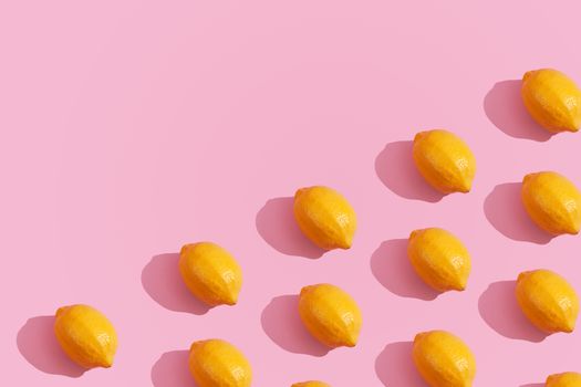 Trendy yellow lemon isometric pattern on pink background. Creative and modern minimal concept. Summer fresh flat lay food texture, copy space.