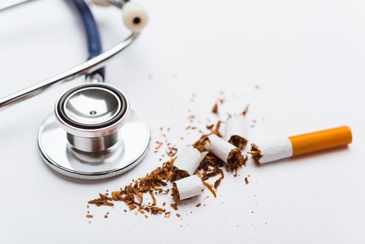 31 May of World No Tobacco Day, no smoking, close up of broken pile cigarette or tobacco and doctor stethoscope on white background with copy space, and Warning lung health concept