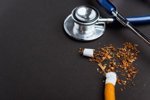 31 May of World No Tobacco Day, no smoking, close up of broken pile cigarette or tobacco and doctor stethoscope on black background with copy space, and Warning lung health concept