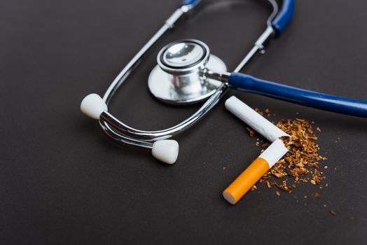 31 May of World No Tobacco Day, no smoking, close up of broken pile cigarette or tobacco and doctor stethoscope on black background with copy space, and Warning lung health concept