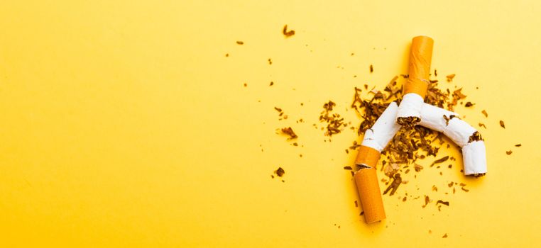 31 May of World No Tobacco Day, no smoking, close up of broken pile cigarette or tobacco STOP symbolic on yellow background with banner copy space, and Warning lung health concept