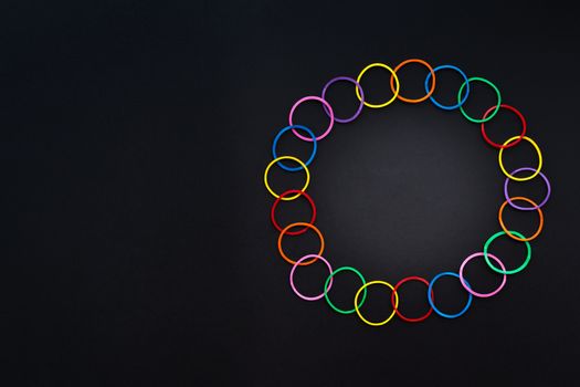 Teamwork concept. group of colorful rubber band on black background with copy space