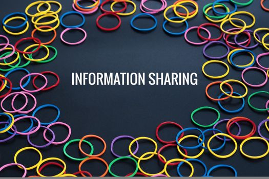 Information sharing concept, colorful rubber band with word Information Sharing on black background