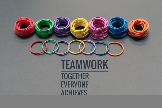 Teamwork concept. group of colorful rubber band on black background with word Teamwork, Together, Everyone, Achieves and More