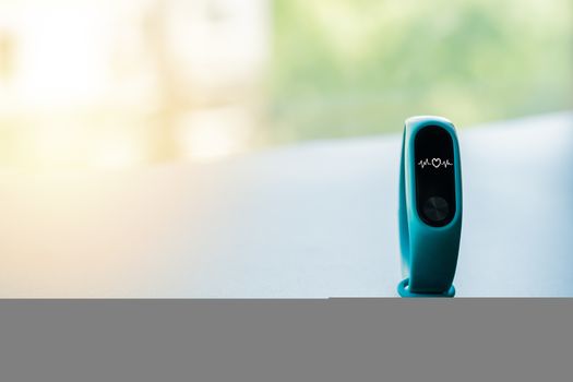 fitness smart band device blue color on black background with heart rate display