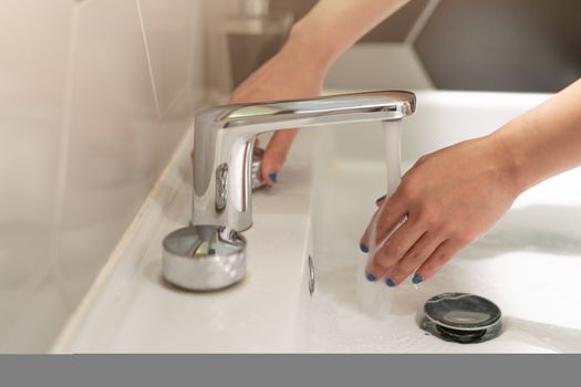 women washing hands under the water fauce. Hygiene concept.