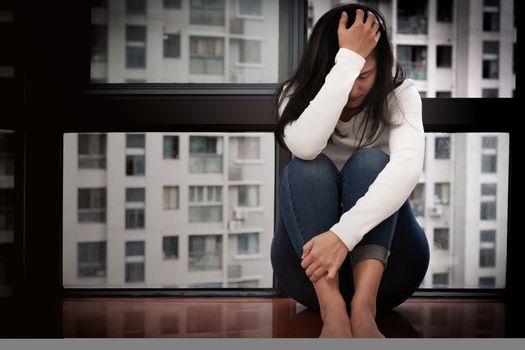 depressed women sitting near window, alone, sadness, emotional concept