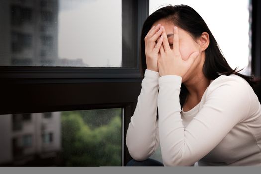 depressed women sitting near window, alone, sadness, emotional concept
