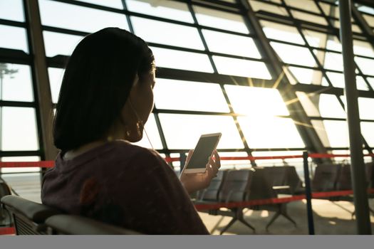 young women searching information while waiting for flying at airport window