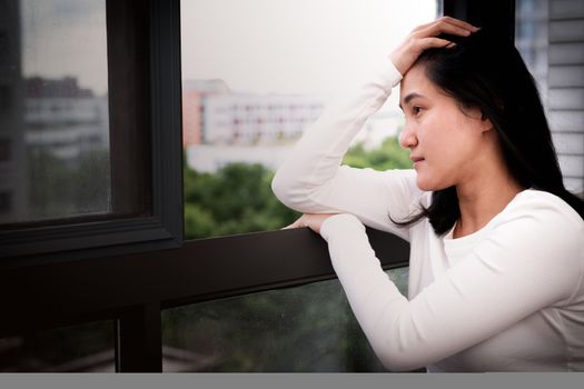 depressed women sitting near window, alone, sadness, emotional concept