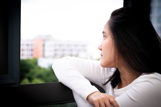 depressed women sitting near window, alone, sadness, emotional concept