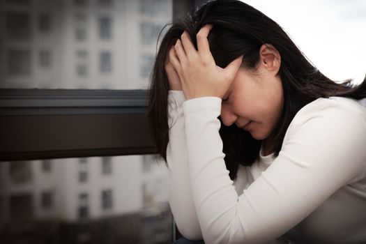 depressed women sitting near window, alone, sadness, emotional concept