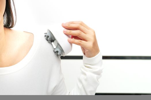 electric arm, neck and shoulder massage machine on women shoulder, closeup, healthcare and medicine concept