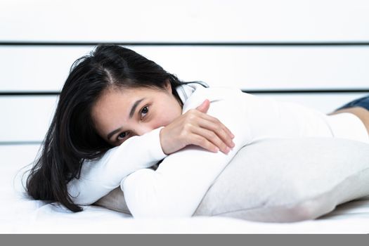 woman lying on pillow in bedroom, portrait happy women look at camera