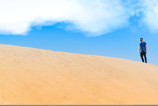 Young man in casual clothes walking forward in the desert