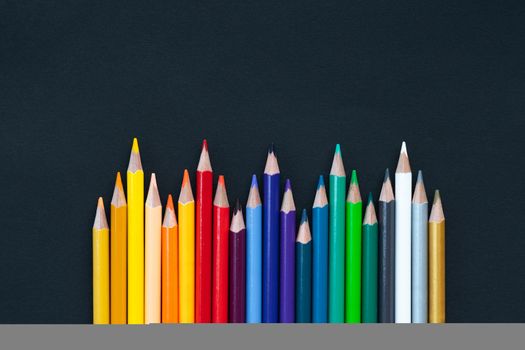 back to school Concept. Close up shot of color pencil pile pencil nibs on black background with copy space