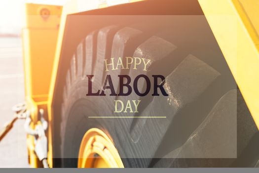 Labor Day Concept. excavator wheel closeup with word Happy Labor Day
