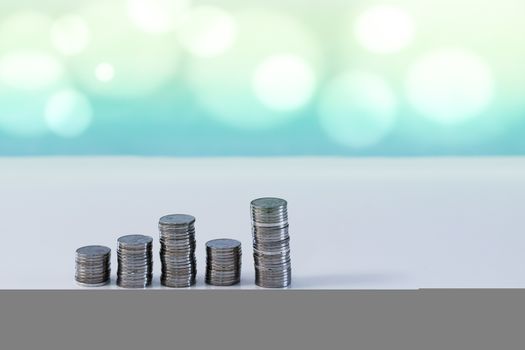 Coin stacks trend up and down on a blue background