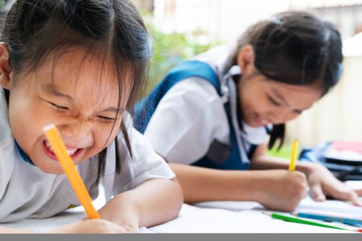 two sister girl writes to writing-books. The decision of lessons. girl lay down drawing the picture