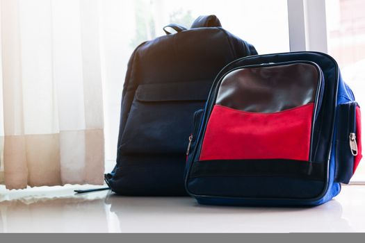 Back to school concept. Blue  backpack lean on the glass door for two kids