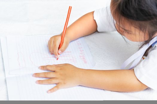 little girl writes to writing-books. The decision of lessons. girl lay down drawing the picture