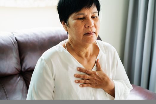 old woman having heart attack and grabbing her chest