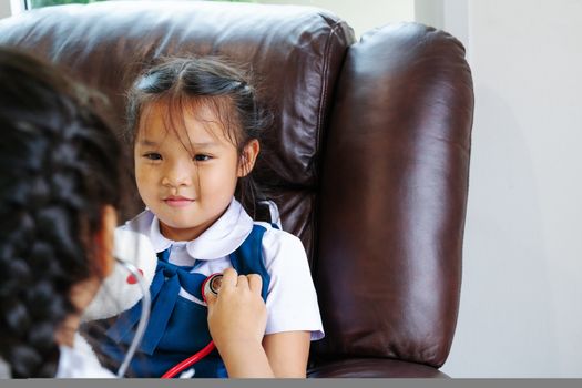 two little girl are smiling and playing doctor with stethoscope. Kid and health care concept.