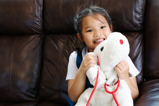 little girl are smiling and playing doctor with stethoscope. Kid and health care concept.