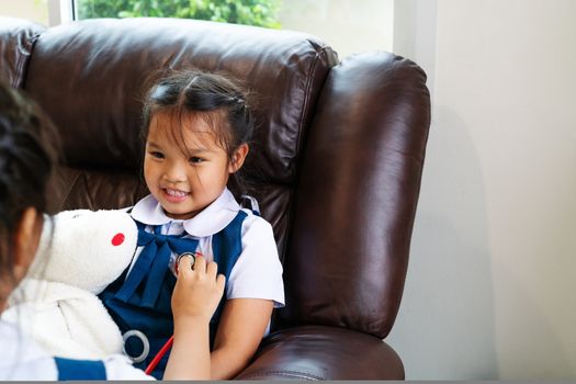 two little girl are smiling and playing doctor with stethoscope. Kid and health care concept.