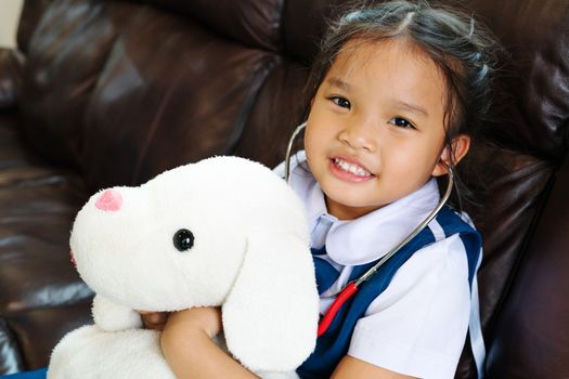 little girl are smiling and playing doctor with stethoscope. Kid and health care concept.