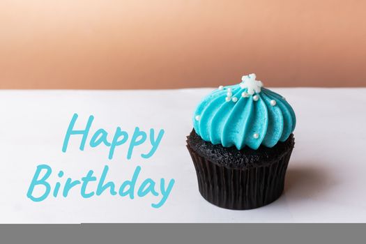 Happy Birthday cute cupcake with small white snow blue cream on white background