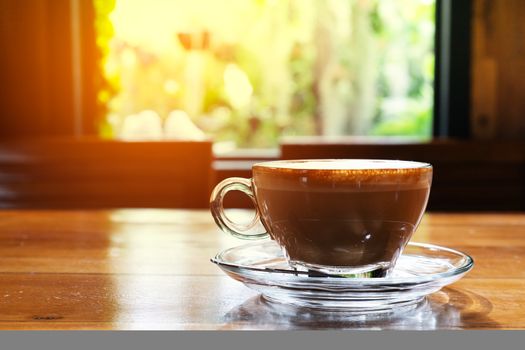 Hot coffee cup on the wooden table, window view
