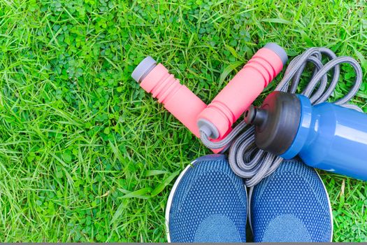 Jump rope, Running shoes, and drink bottle on grass background