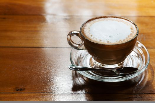 Hot coffee cup on the wooden table, underexposure