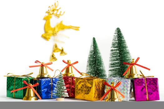 Christmas background concept. Christmas gift box and tree with golden bells, pine cones, on white background