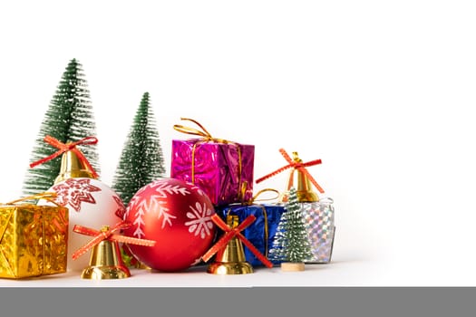 Christmas background concept. Christmas gift box and tree with golden bells, pine cones, red and white ball on white background