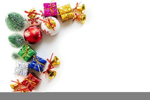 Christmas background concept. Christmas gift box and tree with golden bells, pine cones, red and white ball on white background, top view