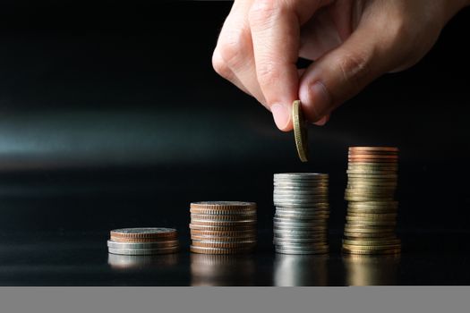 add saving coin to top of coin stack, money saving concept