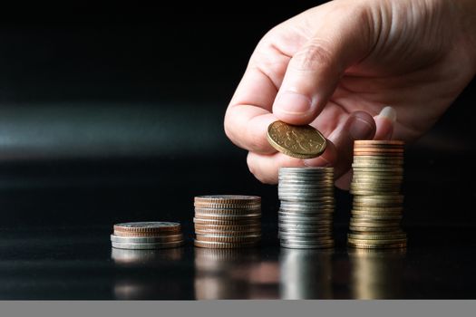 add saving coin to top of coin stack, money saving concept