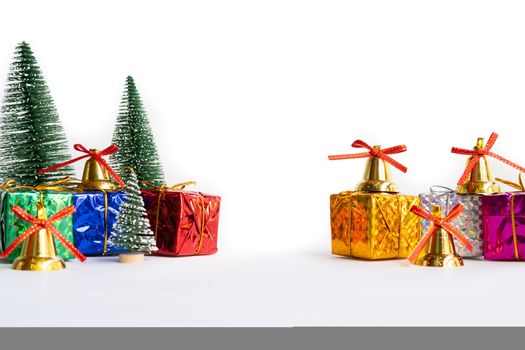 Christmas background concept. Christmas gift box and tree with golden bells, pine cones, on white background
