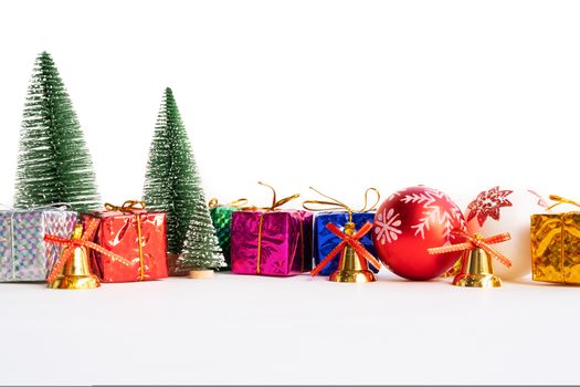 Christmas background concept. Christmas gift box and tree with golden bells, pine cones, red and white ball on white background
