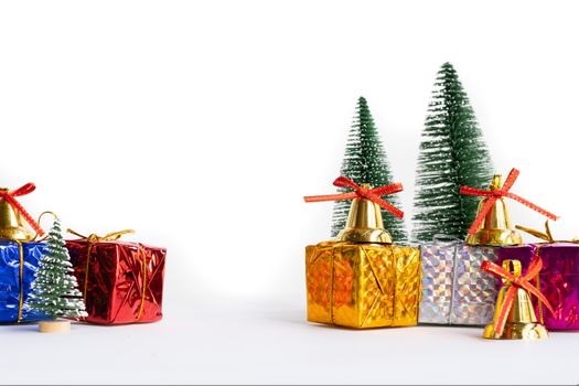 Christmas background concept. Christmas gift box and tree with golden bells, pine cones, on white background