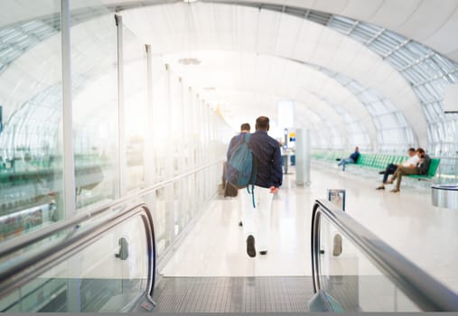 traveler with travel bag or luggage walking in the airport terminal walkway for air traveling. blur motion