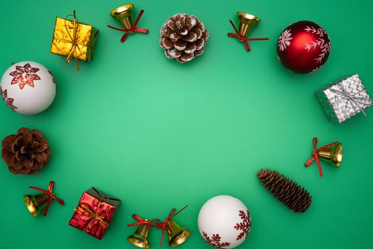 Christmas composition. Christmas gift, bell and ball on green background. Flat lay, top view, copy space