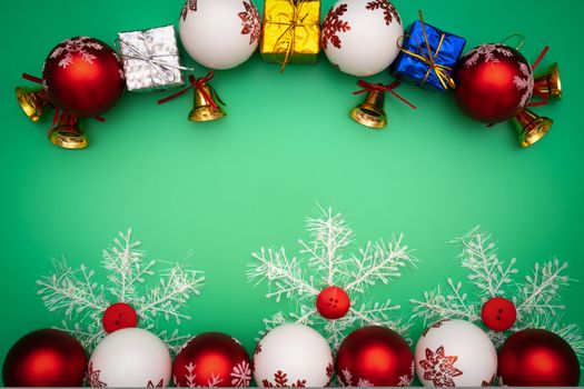 Christmas composition. Christmas gift, bell and ball on green background. Flat lay, top view, copy space