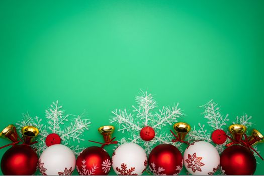 Christmas composition. Christmas gift, bell and ball on green background. Flat lay, top view, copy space