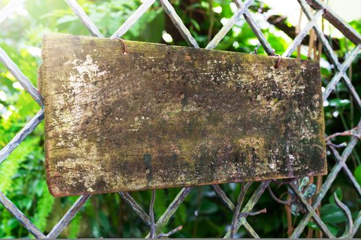 wooden sign board hanging on steel fence