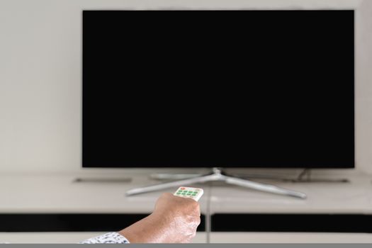 senior women hand hold remote control of TV box watching, blank display