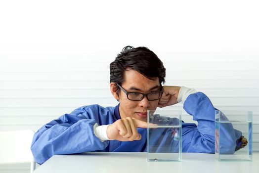 Young Asian Surgeon enjoy watching his new pet fish during lunch break.