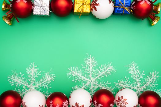 Christmas composition. Christmas gift, bell and ball on green background. Flat lay, top view, copy space